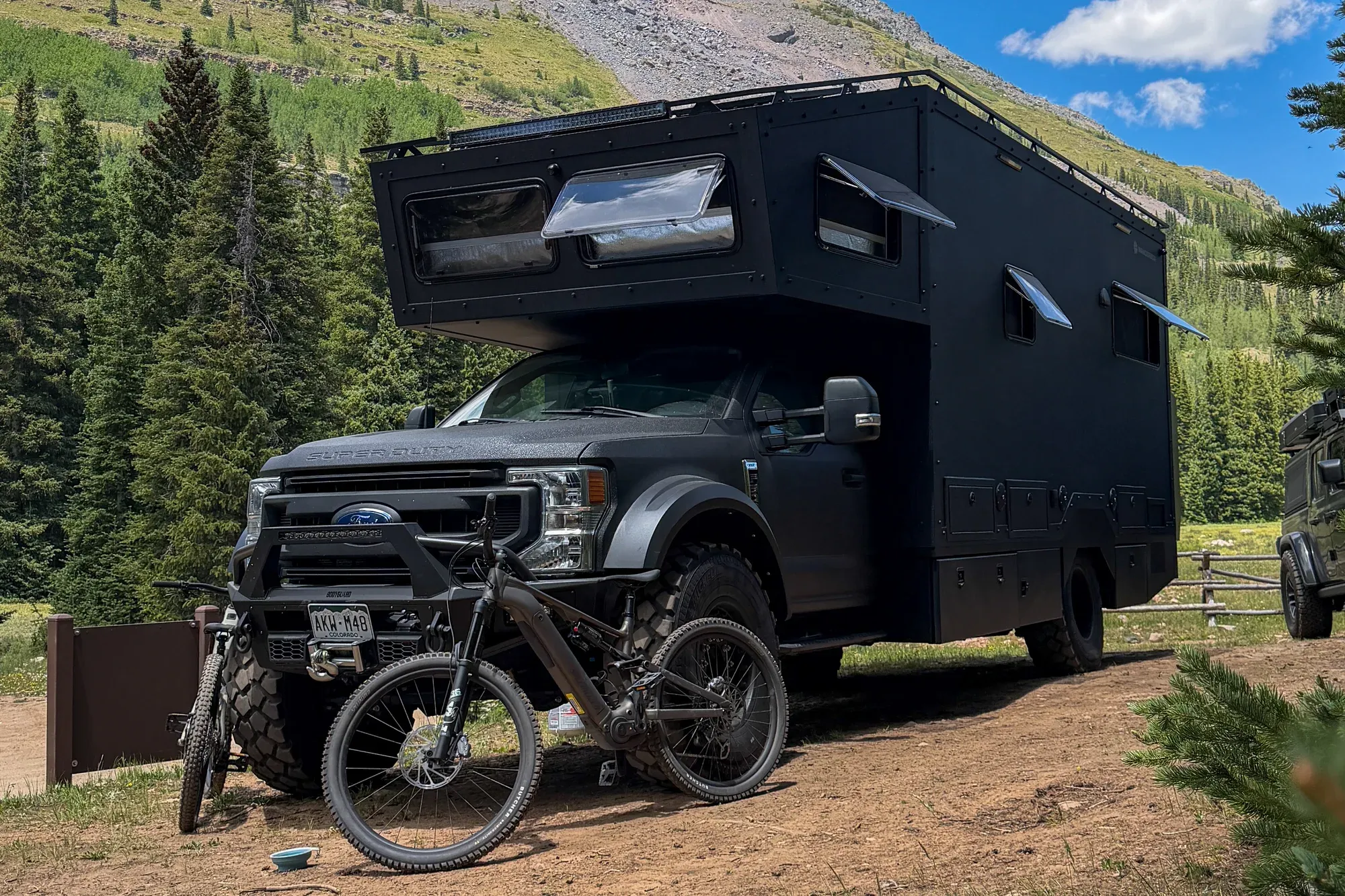 The Wanderbox expedition RV parked below a mountain peak